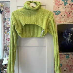 Stickad neongrön halv tröja  - Tröjan har hög nacke som går att vika. Den är kort och går precis över bysten, cool till croptops och linnen under