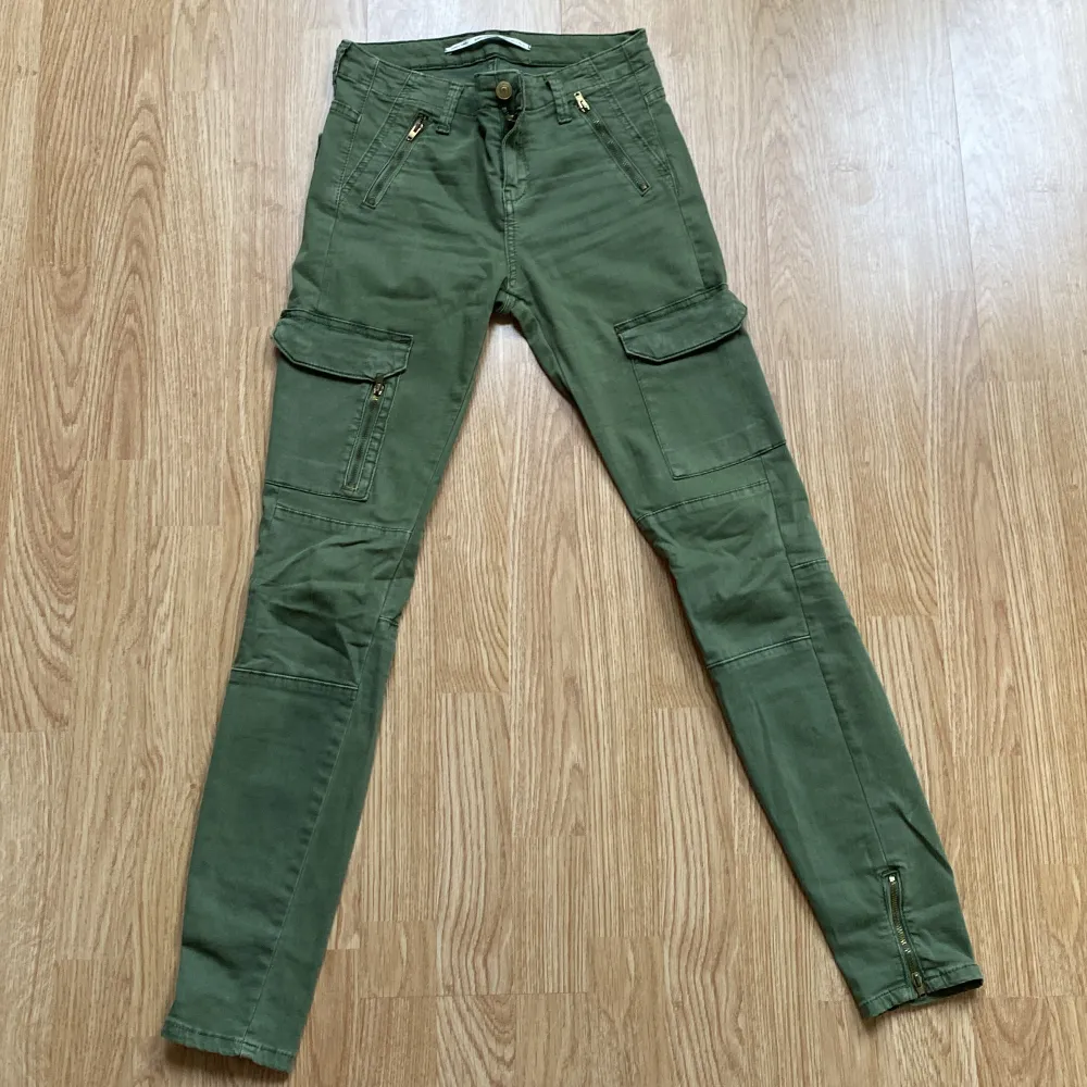 Gröna cargobyxor med guldkedja . Jeans & Byxor.
