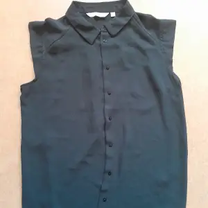 En svart blus med knappar fram, krage samt söta korta ärmar. Snygg till jeans, till exempel. Storlek 38 från Kappahl. Gott skick utan defekter. 