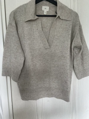 Stickad tröja  - Säljer en v-ringad vit/beige stickad tröja ifrån hm. Den är i storlek xs och har en liten fläck längst ner men det är inget som syns tydligt. 
