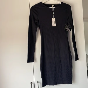 Klänning från Nelly - Perfekta svarta ribbade klänningen från Nelly. Jättebra skick aldrig använd. Sista bilen lånad från hemsidan