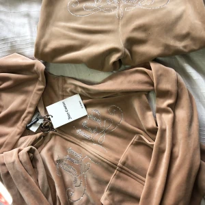 Juicy Couture set  - Helt nytt sett.   Storlek S i topp  Xs i byxorna.   Endast provad.  Alla stenar är kvar (Nyskick)  Nypris ca 2500 kr, kan tänka mig gå ner i pris vi snabbköp