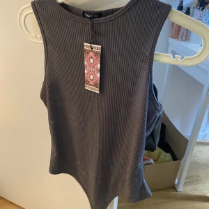 Body helt ny med lappen kvar  - Helt ny body, lappen sitter kvar. 