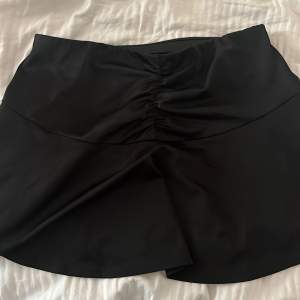 En jättefin svart kjol som rynkas på framsidan i mitten, man kan även ha den bak å fram vilket jag hade den gång jag använde den, nästan helt ny skick och har bara använts någon gång förra året. Passar storlek S 💗