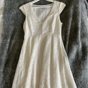 Ciara Forthi klänning - Student/avslutnings klänning. Använd ca 2 gånger, hänger bara i garderoben. Cremevit, från Bubbleroom. Dragkedja finns på sidan.