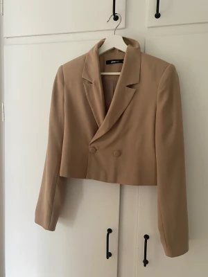 Kort beige kavaj  - Kort beige kavaj från Gina tricot endast använd ett fåtal gånger 