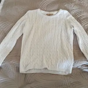 Det här är en äldre design på en Basic U collection tröja. Den är vit och ser lite sliten ut. Det är storlek S. 