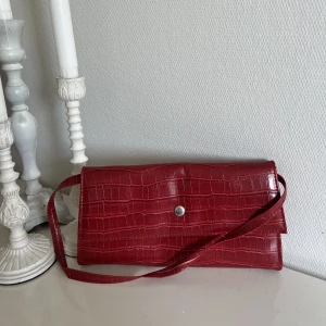 vinröd axelremsväska ❤️‍🔥 - köpt här på plick för nått år sen ❤️ endast använd ett fåtal gånger. har 3 fack varav ett är med blixtlås 