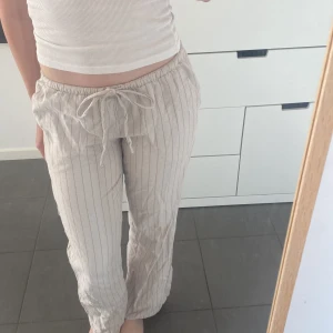 Randiga linnebyxor - Beigea somriga linnebyxor som jag säljer pga för liten i storlek. Lite nötta längst ner men annars i bra skick! De är lågmidjade och passformen är straight leg. Tryck gärna på köp nu!🫶