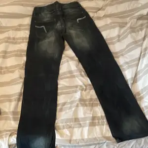 Ett par jeans med tryck på bakfickorna. Nice kvalité. Skriv om frågor