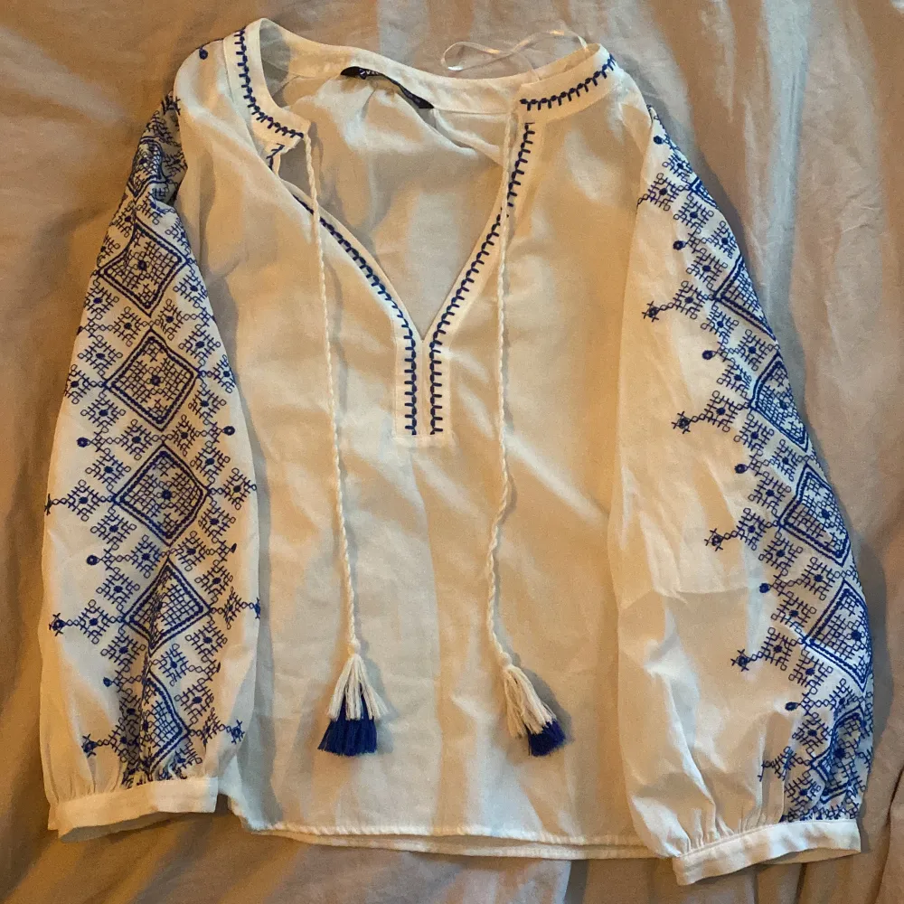 Jättesnygg blus från zara! Vit med blå mönstrat broderi😍 Storlek M men köpt i spanien och spanska storlekar är mindre än svenska så skulle säga att den är S❤️ nästan helt oanvänd!. Blusar.