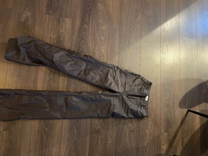 Byxor - Säljer ett par bruna skinnbyxor, på bilden ser den rynkiga ut, det är dem inte, skicka medelande så kan ni få mer bilder! Passar till de med längre ben! Är själv 178 cm.