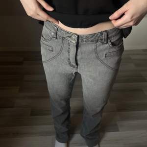 snygga lågmidjade gråa jeans. passar storlek S-M beroende på hur de ska sitt. Modellen är ca 163cm lång.