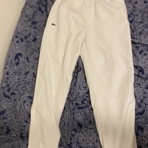 Lacoste byxor - Jag säljer  ett par helt nya vita lacoste byxor i stolek M (herr). Köpt på nk i Stockholm.