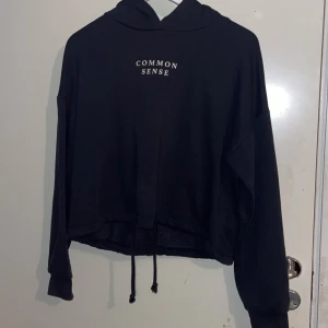Svart hoodie - Svart croppad hoodie från Gina Tricot med trycket ”Common sense”. Storlek S.