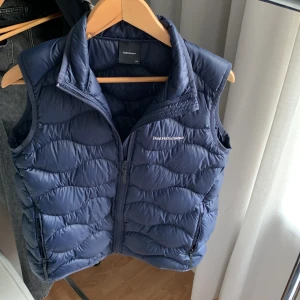 PeakPerformance Väst, Mörkblå - Säljer min oanvända PeakPerformance väst pågrund av felköp, varm och bekväm väst och perfekt till hösten. Storlek: 170