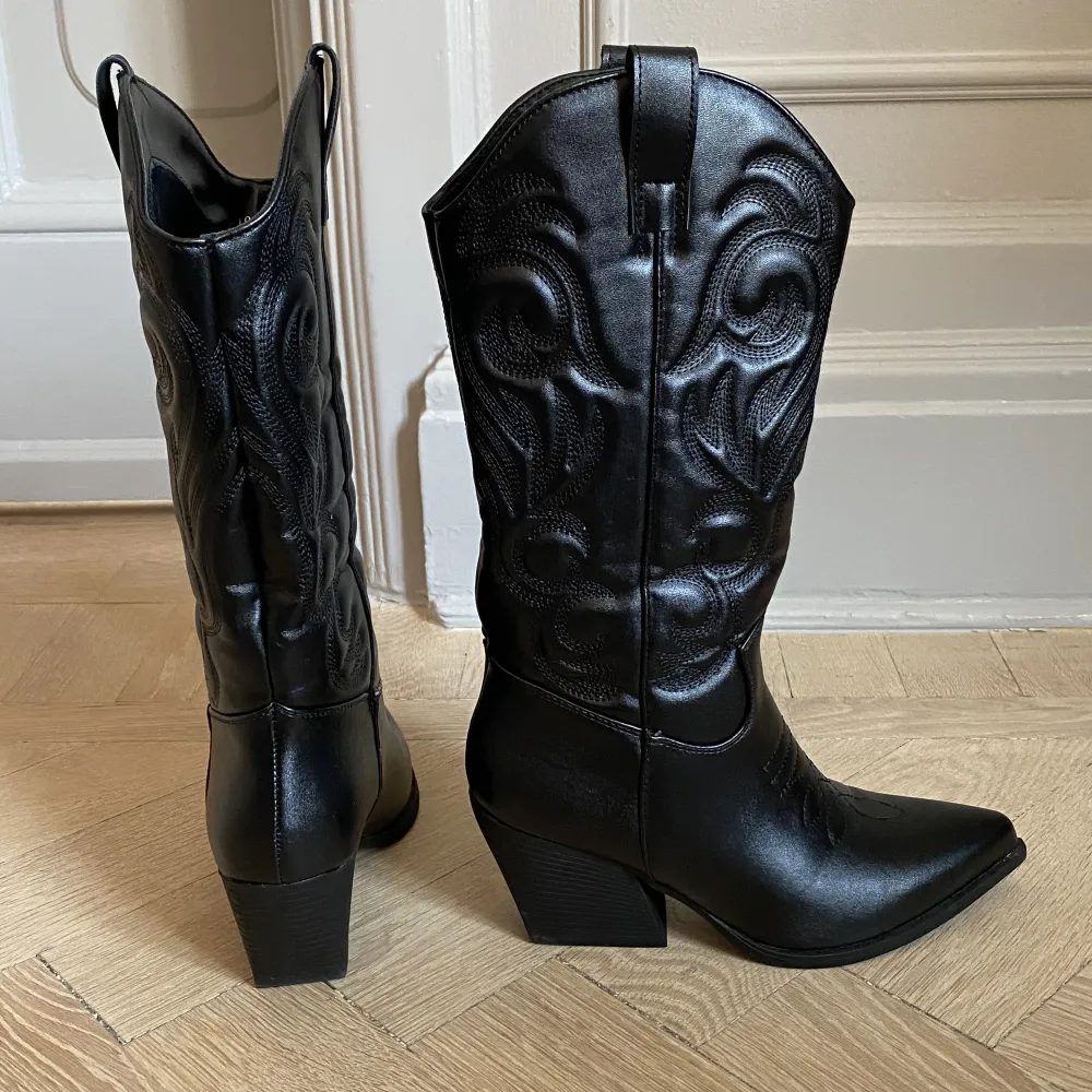 Ett par assnygga svarta cowboy boots som endast är använda 1 gång så de är nästan helt i nyskick. De är så bekväma för de har ett foder som gör att man inte får skavsår. De är i storlek 36 men jag har storlek 37 och det passar super bra. Bekväm klack. . Skor.