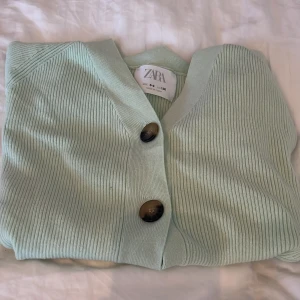 Ljus grön kofta - Grön kofta.brun svarta knappar.