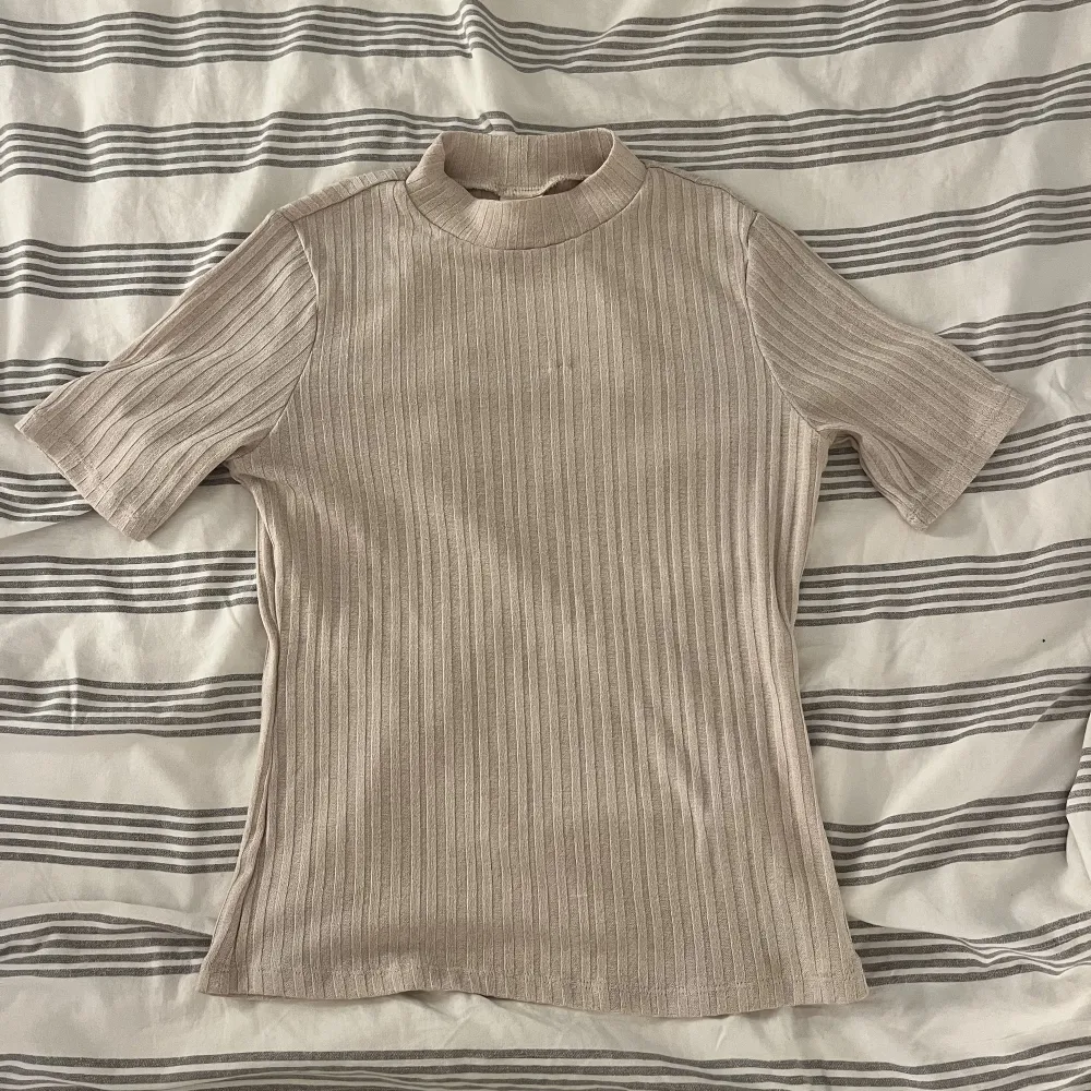 Beige tshirt från HM i storlek S. Jättefin, dock har en tråd lossnat fram på bröstet, därav priset🤗. T-shirts.