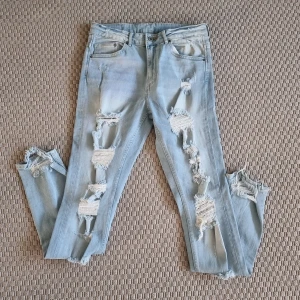 Jeans  - Ljusblå lite stretchiga jeans med mycket slitningar. Skinny high waist. Aldrig använda. 