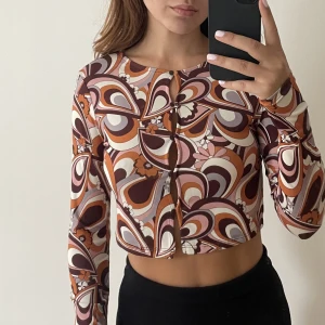 Tröja från Berhska - Mönstrig tröja från Behrska i croppd modell med knäppning framtill. Bra plagg att både klä upp och klä ner! Är i nyskick och storlek s men passar även xs.