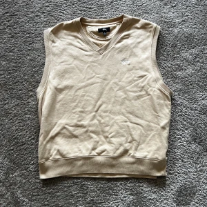 Beige stussy vest - Beige stussy vest med broderad stussy logo på bröstet. I mycket bra skick knappt använd. Nypris 1000