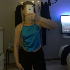 satin topp - Säljer en blå satin topp som man knyter bakom nacken och ryggen från bershka! Den är helt ny och har prislappen kvar på sig! ☺️