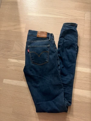 Levis 710 super skinny strl 25x30 - Ett par mörkblå jeans från Levis i modell 710. Super skinny fit och lågmidja. I fint skick!  Storlek 25 Benlängd 30