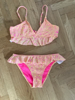 Supersnygg bikini från We wear knappt använd - Jättefin bikini, gul och rosa, från märket We are We wear, köpt på Zalando, bara använd några gånger. Stl 158 / 164