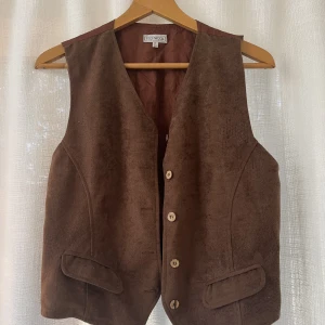 Vintage kostymväst - Snygg brun kostymväst. Bra skick, knappt använd:) stl 38, har ett band i ryggen som kan justeras. 