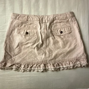 Jeans kjol - Jättesöt lågmidjad kjol från h&m med snygga detaljer på baksidan. Köpt second hand. Den ser mer beige ut på bilderna men är mer ljus rosa. Pris kan diskuteras. 78kr + frakt. Tryck gärna på köp nu💗