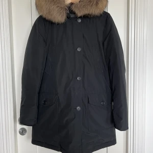 Woolrich - Dunjacka  - Jättefin höst/vinter jacka i super fint skick! Den har en jättefin äkta päls runt luvan som är avtagbar. 