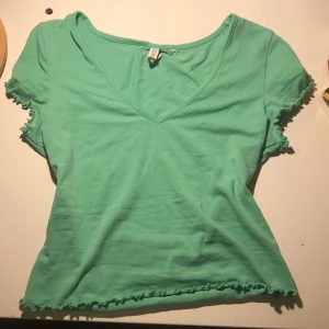 H&m t-shirt  - Jätte söt grön h&m tröja med fina detaljer vid ärmarna och längst ner på tröjan. Lappen med storleken är bort klippt men skulle tro att det är en s-xs.💗💗 Pris: 20kr
