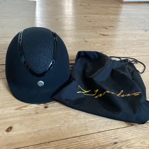 Ridhjälm  - Ridhjälm från Back On Track Använd 6 månader/ 1 gång i veckan  Nyskick  Aldrig slagit i backen eller tappat den, hjälmpåse medföljer! Köpt för 2499kr