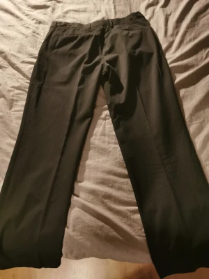 Finbyxa, mörkbrun/grå med längsgående ljusa streck, 33/32 - Finbyxa bättre begagnad. Stl 33/32. Märke Producer. Knäppning clips , dragkedja. 