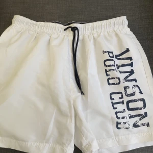 Vinson polo club shorts - Vita vinson polo club shorts som är i storlek L och är i badbyxor tyg. Passar till allt möjligt som t.ex träning, badbyxor, vanliga shorts osv.  Knappt använda.  Står för tvätt innan leverans. 