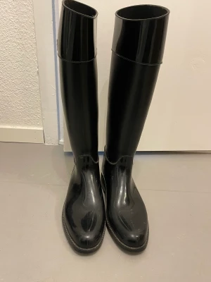 Calvin Klein Gummistövlar stl 39 40 - Säljer dessa super snygga stövlarna från Calvin Klein. Sparsamt använda. Svarta glansiga. Storlek 40 men små i strl så passar en 39💗 