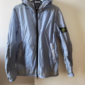 Stone island windbreaker  - Säljer en stone island windbreaker, i väldigt bra skick på jackan! Den har ett litet jack på magen som knappt syns, se bild! Enkelt att laga hos en skräddare.