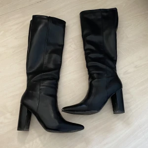 Svarta stövlar - Svarta stövlar med klack i storlek 8 1/2 dvs ungefär 39. De är fina men har små skavanker då de är använda(sista bilden). Inget som syns särskilt mycket egentligen
