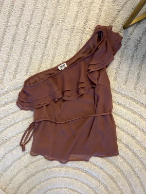 Blus - En somrig fin blus med en Axel och band i midjan. Från Carolina Gynnings kollektion från bubbleroom. I storlek 36⭐️