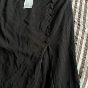Helt oanvänd svart kjol med slits från H&M.