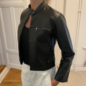Vintage skinnjacka  - Snygg svart skinnjacka med spänne upptill och fickor. Lappen är bortklippt men skulle tippa på att storleken är mellan XXS-XS. Jag på bilden har vanligtvis S!