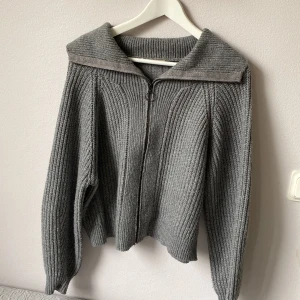 Stickad kofta - Jättehärlig och mysig stickad tröja med dragkedja. Kan ha som en halternecktröja men också ha den öppen som en kofta! Man kan bära den på olika sett. I storlek S i fint skick! 