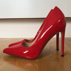 Högklackade pumps. - Pumps i högglans. 12 cm klack. Aldrig använda. 