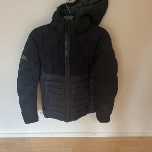 Vinterjacka  - Superdry vinterjacka dom har en lagning på baksidan där av priset