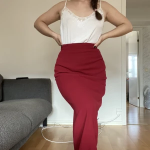 Vinröd lång kjol  - Lång kjol. Typ kostymkjol i 50-talsstil. Jätte fin! Den är 84cm lång.