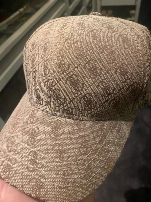Keps Guess - Beige keps från Guess