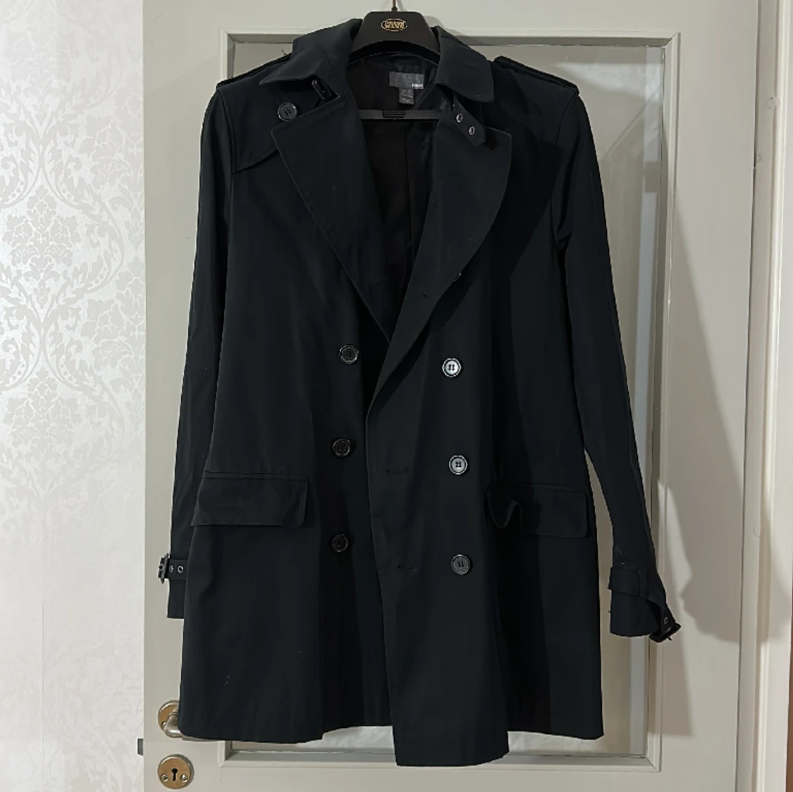 Fin svart kappa med bälte i midjan. 