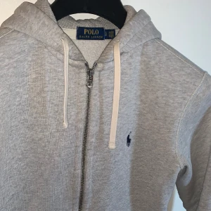 Polo Ralph Lauren Hoodie (grå)  - Ralph Lauren kofta/hoodie i storlek S. Väldigt fint skick 9/10, säljer endast för att den har blivit för liten för mig. Äkta såklart