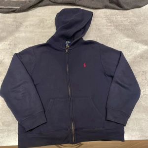 Polo Ralph Lauren zip hoodie - Blå. L/6 (14-16).   https://www.ralphlauren.eu/se/en/authenticated?countryCode=SE&thngID=VxpnPSQn6YBH6DwTwPwF2k6e&webstoreAvailable=false